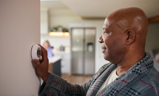 man adjusting thermostat